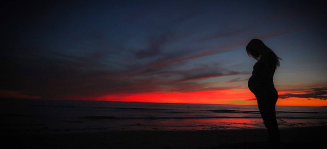 silhouette of a pregnant woman against a sunset