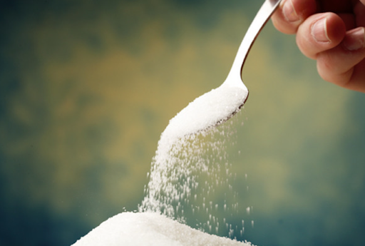 Image of a spoon pouring sugar onto a pile of sugar